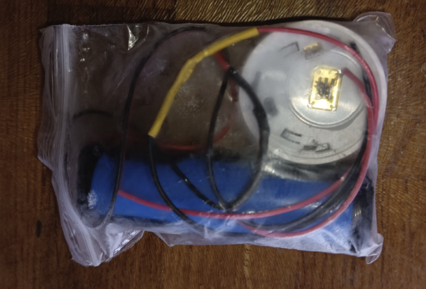 The same thing, showing wires soldered to the compartment. Negative in the centre, positive where the CR2032 rim would touch